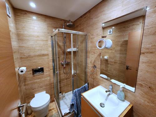 a bathroom with a shower and a toilet and a sink at Shell Bay Retreat in São Martinho do Porto