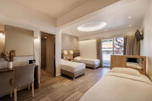 a hotel room with two beds and a desk and a chair at Xenophon Hotel in Athens