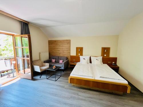 a bedroom with a large bed and a couch at Gästehaus Huber - Hotel Garni in Bad Füssing