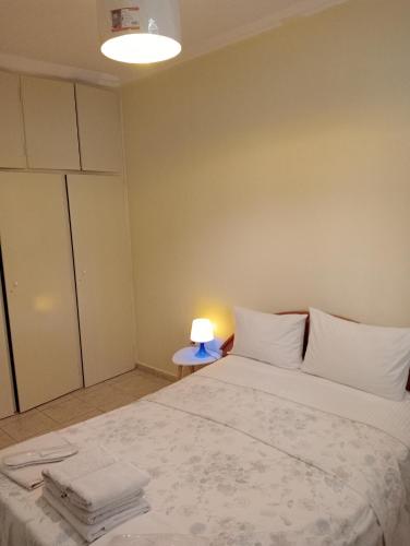 a bedroom with a bed and a lamp on a table at Stydio Damos in Kavála