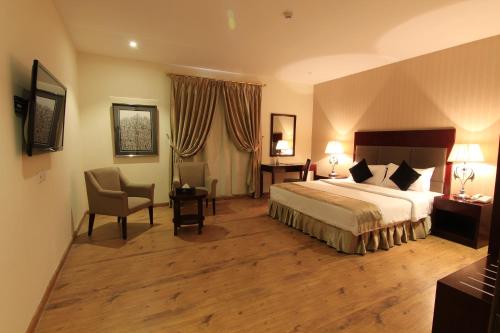 um quarto de hotel com uma cama e uma cadeira em Aliah Towlan Palace em Riyadh