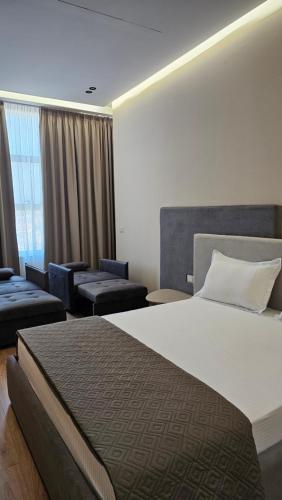 a hotel room with a large bed and chairs at The Center 104 in Polisi i Vogël
