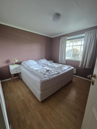 a bedroom with a large white bed and a window at Apartment on Leknes with a view in Vestvågøya