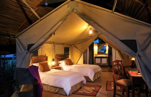 a bedroom with two beds in a tent at Sweetwaters Serena Camp in Nanyuki