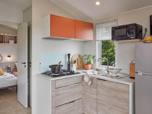 a kitchen with a sink and a stove top oven at CAMPING PLEIN SOLEIL in Lourdes