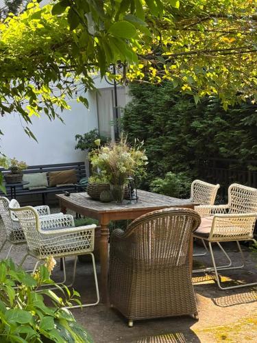 a table with wicker chairs and a table with flowers on it at Willa Urocze in Muszyna