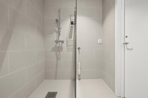 a shower with a glass door in a bathroom at Skudeløken Apartment Hotel in Førde