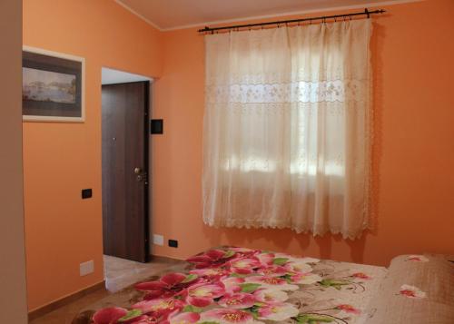 a bedroom with a bed with pink flowers on it at Agriturismo I TRE TIGLI in Rignano Flaminio