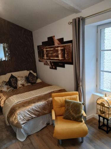 a bedroom with a bed and a chair and a window at La Terrasse Salon de The in Montmorillon
