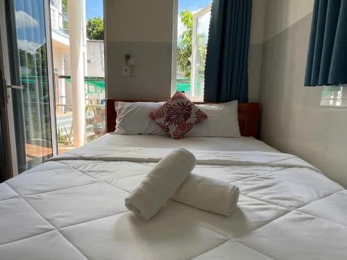 a large white bed with two towels on it at VitaSea Mui Ne homestay & pool in Mui Ne