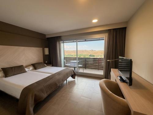 a hotel room with a bed and a large window at Hotel Balneario de Gravalos in Grávalos