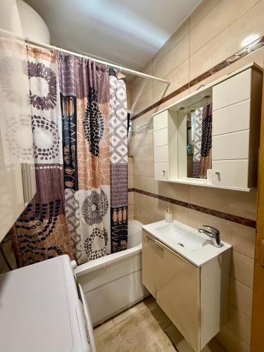 a bathroom with a sink and a shower curtain at Apartment CenterZeroZone in Banja Luka