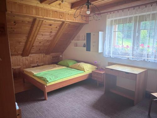 a bedroom with a bed with a wooden ceiling at Chalupa Pavlonka in Staré Hamry