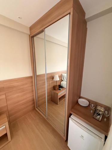 a large mirror in a room with a bed at Vista Azul Hotel Frente Pedra Azul in Pedra Azul