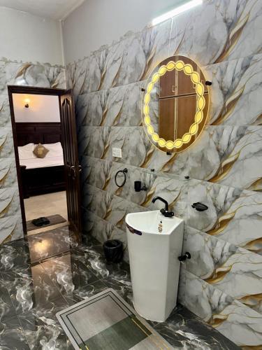 a bathroom with a sink and a mirror at Beach Heaven Guest House in Karachi
