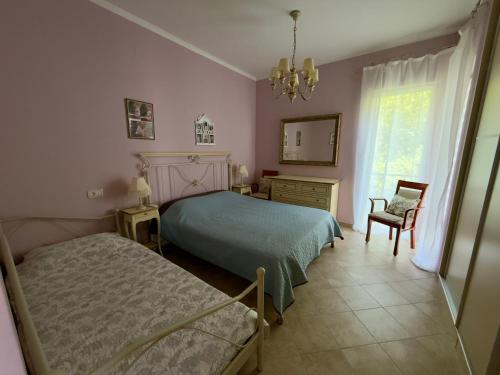 a bedroom with two beds and a chair and a mirror at GH Mountain & Bay View with POOL in Gornji Orahovac