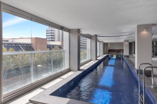 a swimming pool in a building with large windows at Swainson at Embassy in Adelaide