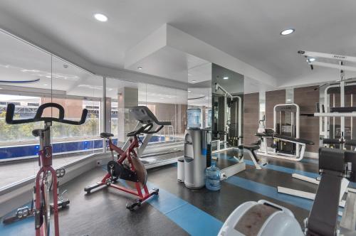 a gym with a treadmill and ellipticals in a room at Swainson at Embassy in Adelaide