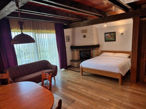 a bedroom with a bed and a couch and a table at Vineyard Cottage - Ana in Metlika