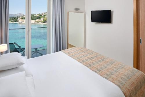 a bedroom with a bed with a view of the water at Maistra Select Mlini Villas and Apartments in Mlini