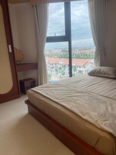 a bed in a room with a large window at Sunora Stay A6 in Quang Ãm