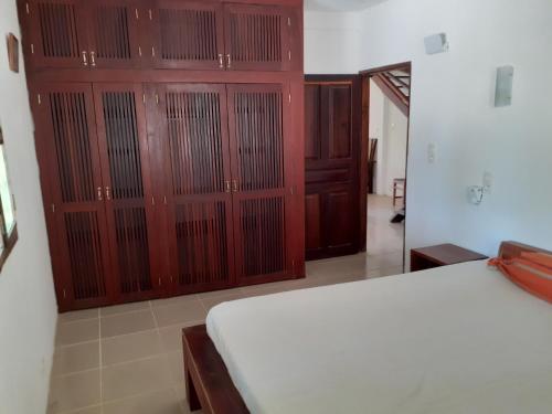 a bedroom with wooden lockers and a white bed at Villa Armor 2 in Nosy Be