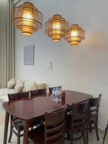 a dining room table with chairs and chandeliers at Sunora Stay A6 in Quang Ãm
