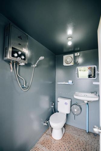 a bathroom with a toilet and a sink at หยดฝน โฮมสเตย์ in Mon Jam