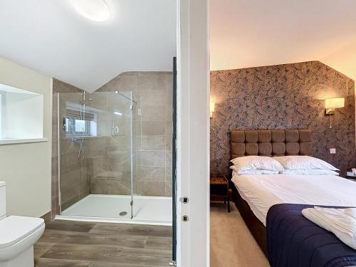 a bedroom with a shower and a bed and a tub at George and Dragon in Holmesfield