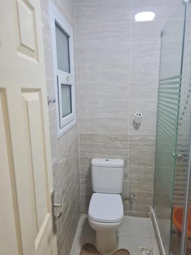 a bathroom with a toilet and a glass shower at شاليه بلومار السخنة in Ain Sokhna