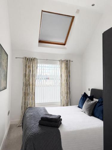 a bedroom with a bed with a mirror and a window at Seaview Hideway - Abnb in Portstewart