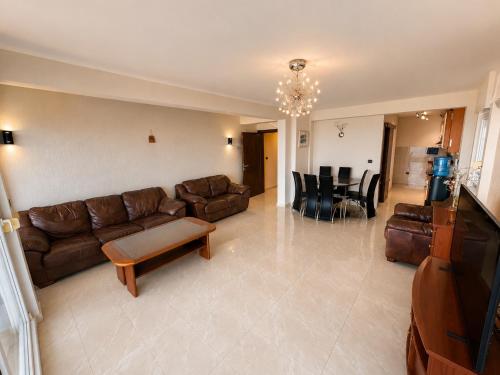 a living room with a couch and a table and chairs at Penthouse Bečići Apartament in Bečići