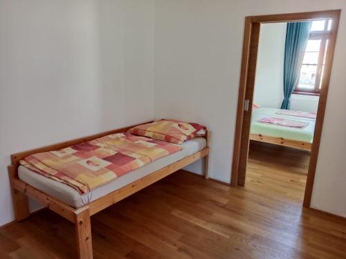 a small bedroom with a bed and a mirror at Apartmán Netolice in Netolice