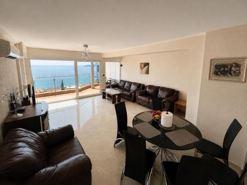 a living room with a table and a couch at Penthouse Bečići Apartament in Bečići