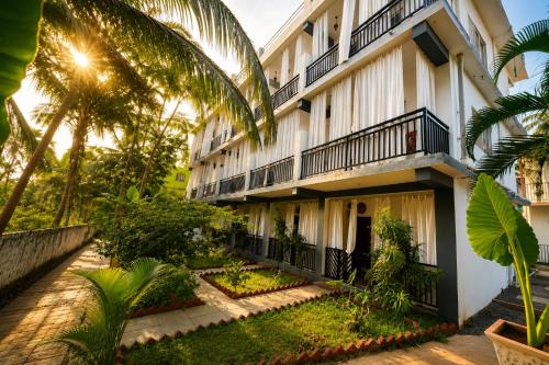 an exterior view of a building with palm trees at Casa de Arambol in Arambol