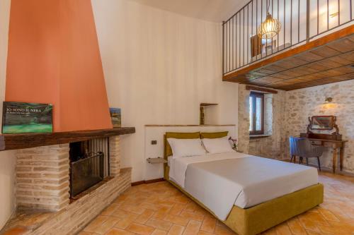 a bedroom with a bed and a fireplace at Borgo San Valentino in Arrone