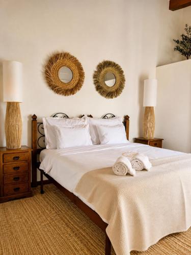 a bedroom with a bed with two towels on it at Herdade Da Corte in Tavira
