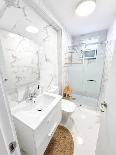 a white bathroom with a sink and a toilet at Nido del Sol in Guía de Isora