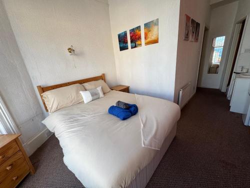 a bedroom with a white bed with a blue object on it at Mirage Hotel in Blackpool