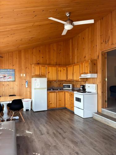 a kitchen with white appliances and a ceiling fan at Parlee Beach Motel in Shediac