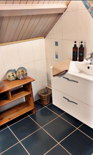 a bathroom with a sink and a tiled floor at Domaine de la Borde in Damparis