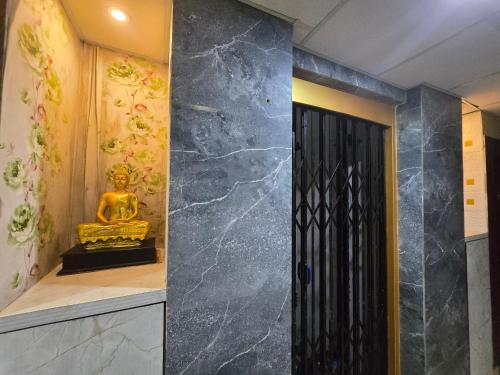 a room with a buddha statue next to a door at Hotel JBL in kolkata