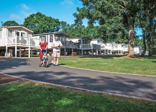 a man and a woman walking with a baby in a stroller at Heather View Holiday Park in Stanhope