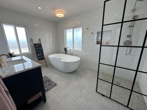 a white bathroom with a tub and a sink at The View Villa in Hartswell