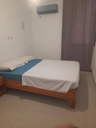 a small bed in a room with a white mattress at Résidence habitat nimbo in Bouaké