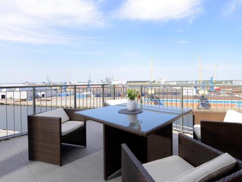 a patio with a table and chairs on a balcony at Ohlerich Speicher App_ 46 in Wismar