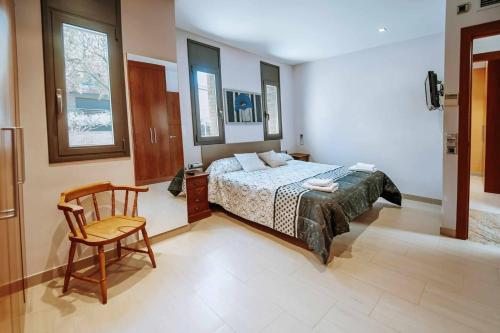 a bedroom with a bed and a chair in it at Casa La Vinya "Alto Standing" in Palamós
