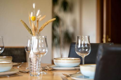 a table with glasses and a vase with a flower in it at Haus Fine in Millstatt