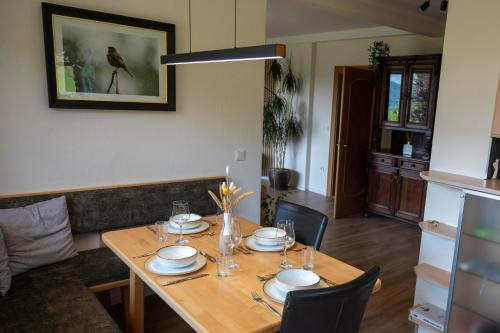 a dining room table with plates and glasses on it at Haus Fine in Millstatt