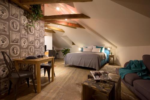 a bedroom with a bed and a table and a couch at Romantic Bohemian Studio in Old Town Prague in Prague